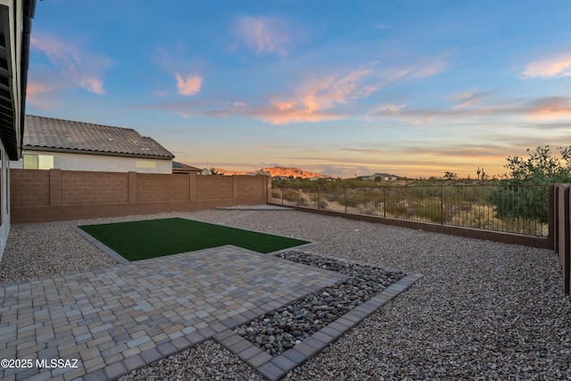 yard at dusk with a patio area