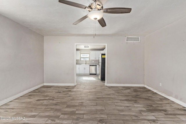 unfurnished room with ceiling fan and sink