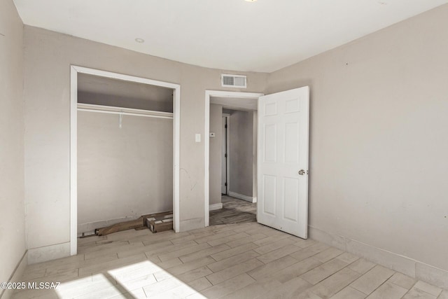 unfurnished bedroom with light hardwood / wood-style floors and a closet