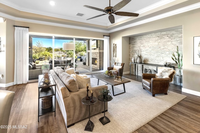 living room with hardwood / wood-style floors, ornamental molding, and a fireplace