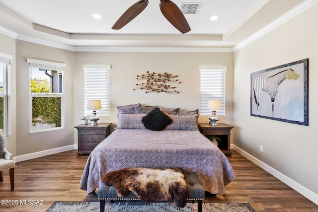 bedroom with ceiling fan, a raised ceiling, wood-type flooring, and ornamental molding