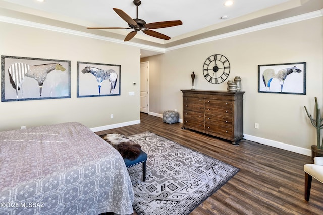 bedroom with dark hardwood / wood-style floors, ceiling fan, crown molding, and a tray ceiling