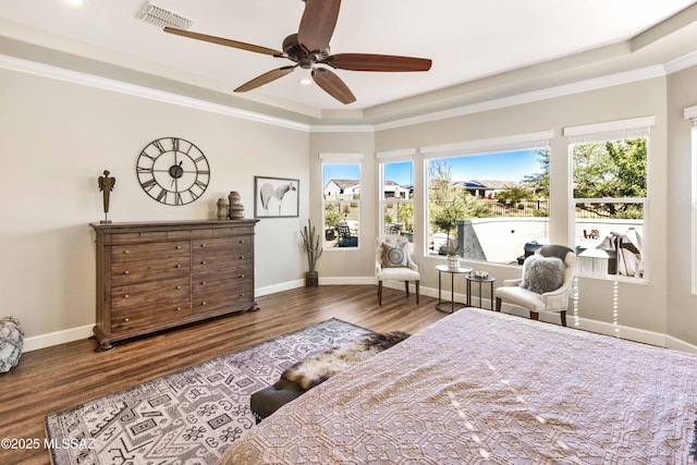 bedroom featuring wood-type flooring, a tray ceiling, ceiling fan, and crown molding