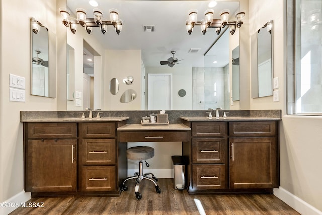 bathroom with hardwood / wood-style flooring, ceiling fan, a shower, and vanity