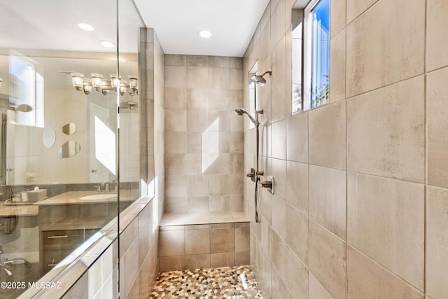 bathroom featuring sink, tiled shower, and tile walls