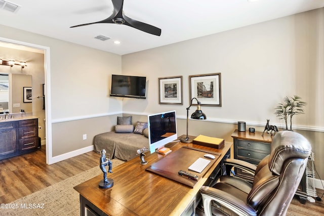 office area with ceiling fan, dark hardwood / wood-style flooring, and sink