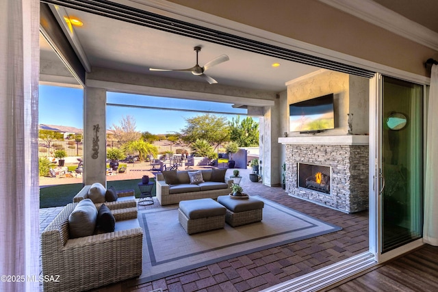 living room featuring an outdoor stone fireplace, ceiling fan, and ornamental molding