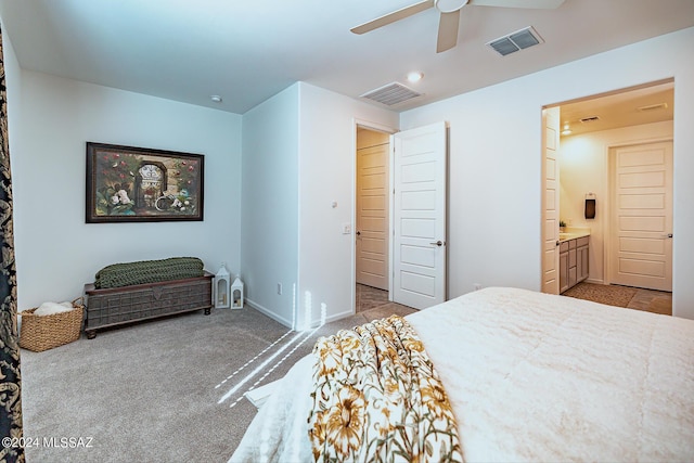 carpeted bedroom with ensuite bath and ceiling fan