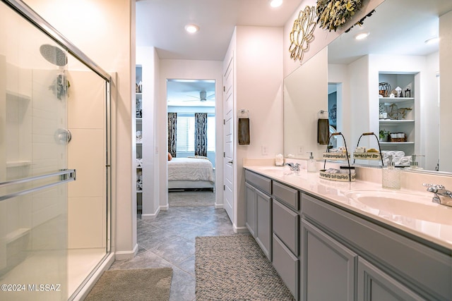 bathroom featuring vanity, ceiling fan, a shower with shower door, and built in shelves