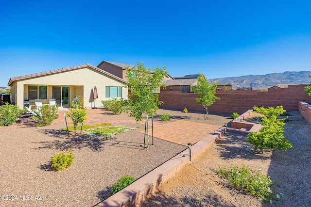 rear view of property featuring a mountain view and a patio area