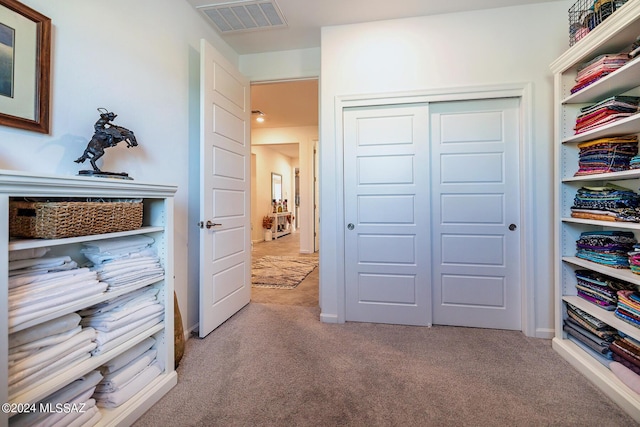 bedroom featuring light colored carpet and a closet