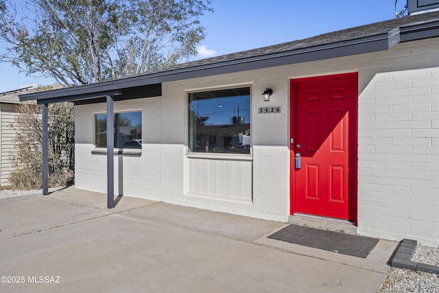 view of exterior entry with a patio area