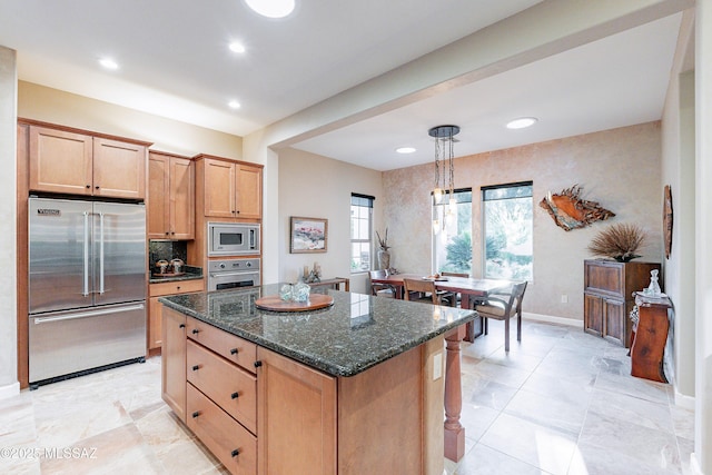 kitchen with tasteful backsplash, dark stone counters, pendant lighting, a kitchen island, and appliances with stainless steel finishes