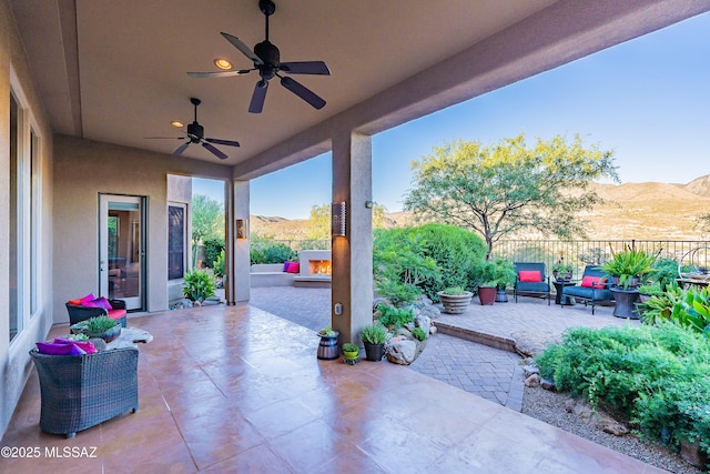 view of patio featuring ceiling fan and a mountain view