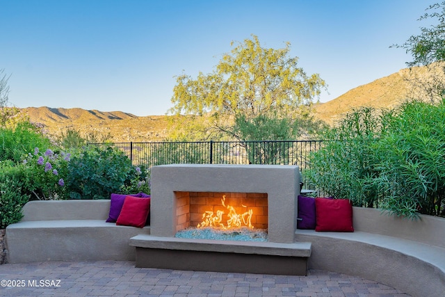 view of patio / terrace featuring a mountain view and exterior fireplace