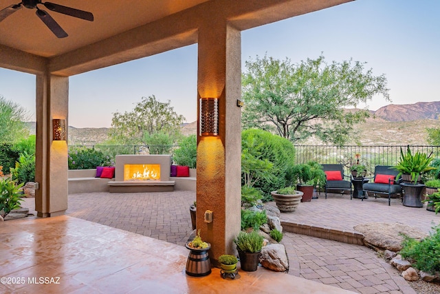 patio terrace at dusk with a mountain view and ceiling fan