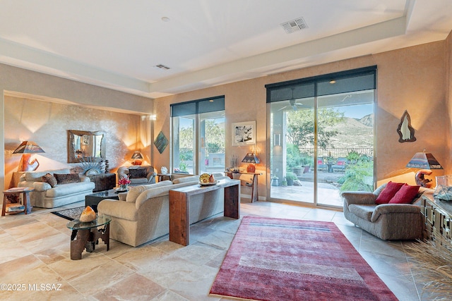 living room featuring a mountain view and a raised ceiling