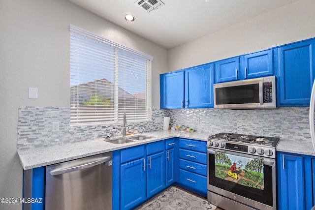 kitchen featuring decorative backsplash, sink, blue cabinets, and stainless steel appliances