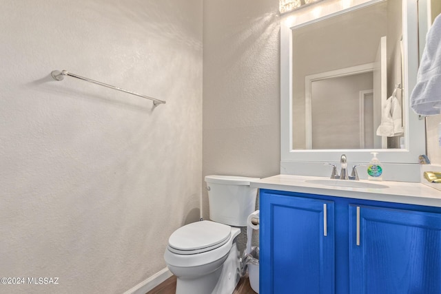 bathroom with hardwood / wood-style floors, vanity, and toilet