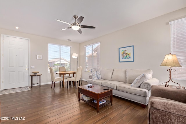 living room featuring ceiling fan and dark hardwood / wood-style floors