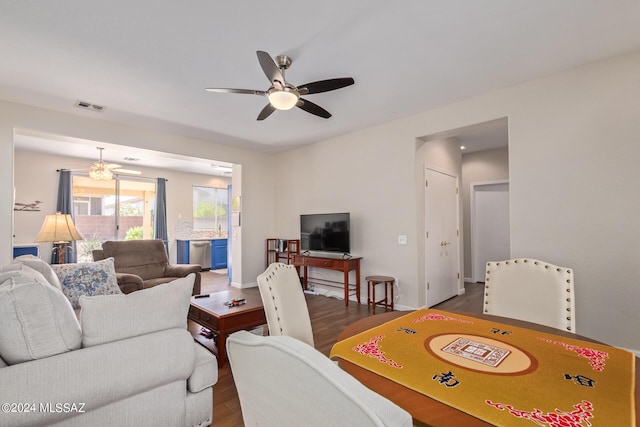 living room with ceiling fan and dark wood-type flooring