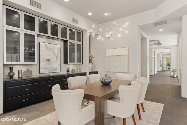 dining area featuring light tile patterned floors and an inviting chandelier