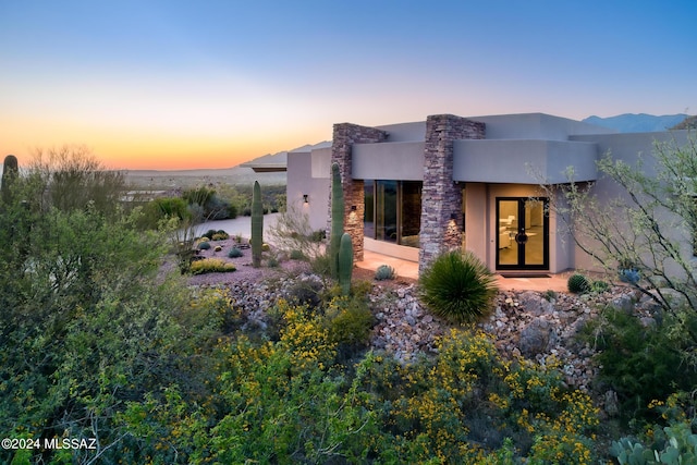 back house at dusk featuring a mountain view