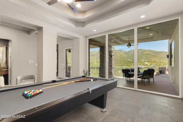 recreation room with a mountain view, a raised ceiling, ceiling fan, and billiards