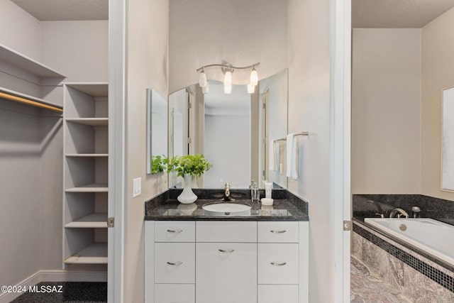 bathroom featuring vanity and tiled tub