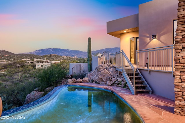 pool at dusk featuring a mountain view