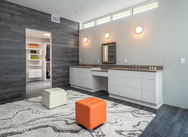 bathroom with hardwood / wood-style floors, vanity, wood walls, and tile walls