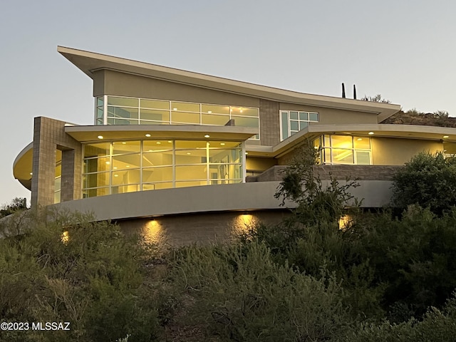 view of back house at dusk