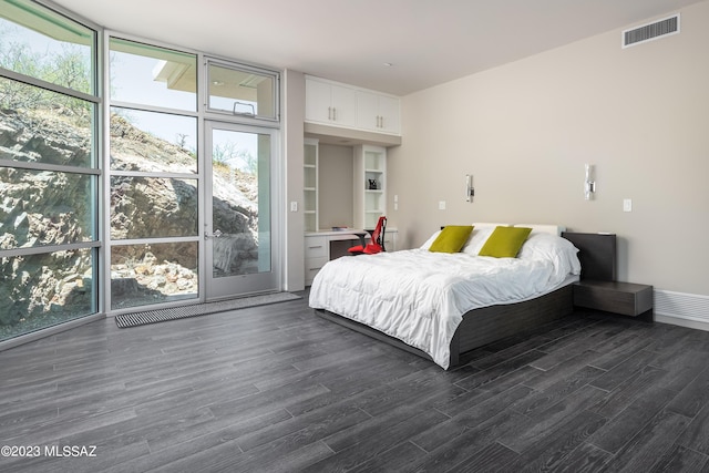 bedroom with dark hardwood / wood-style floors and floor to ceiling windows