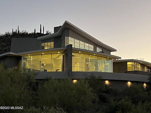 property exterior at dusk with a sunroom