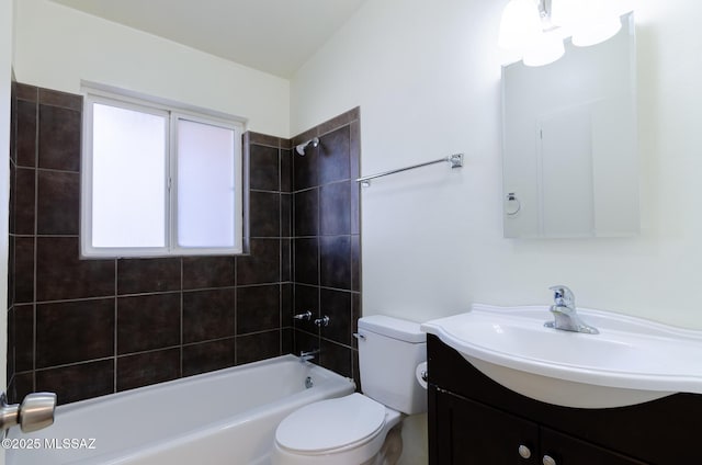 full bathroom featuring vanity, tiled shower / bath combo, and toilet