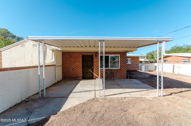 rear view of house featuring a carport and central AC