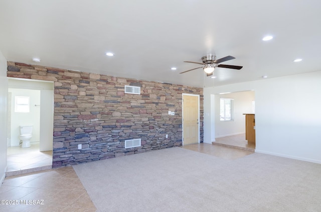 unfurnished living room featuring ceiling fan and light tile patterned flooring