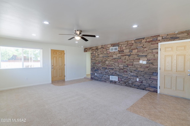 spare room with ceiling fan and light colored carpet