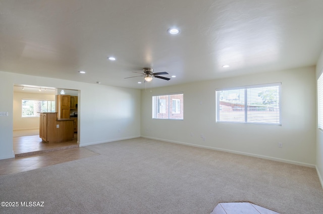 carpeted spare room featuring ceiling fan