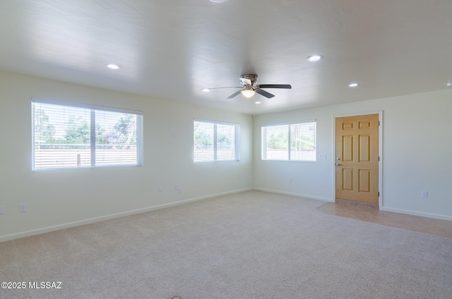 carpeted spare room featuring ceiling fan