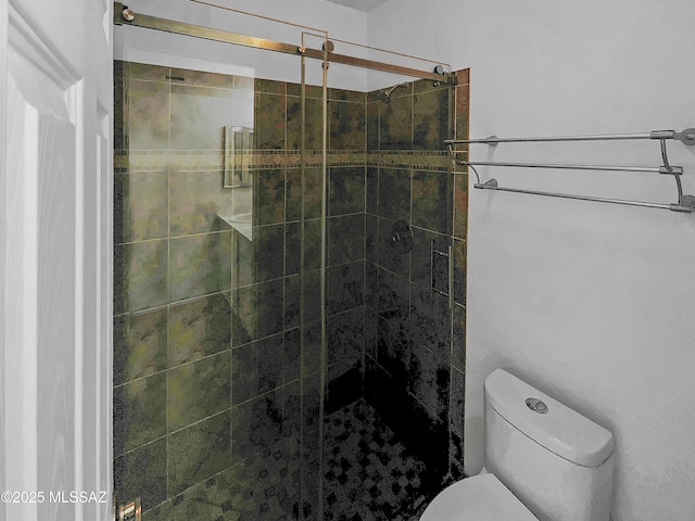 bathroom with toilet and an enclosed shower