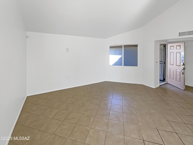 unfurnished room featuring light tile patterned floors and vaulted ceiling