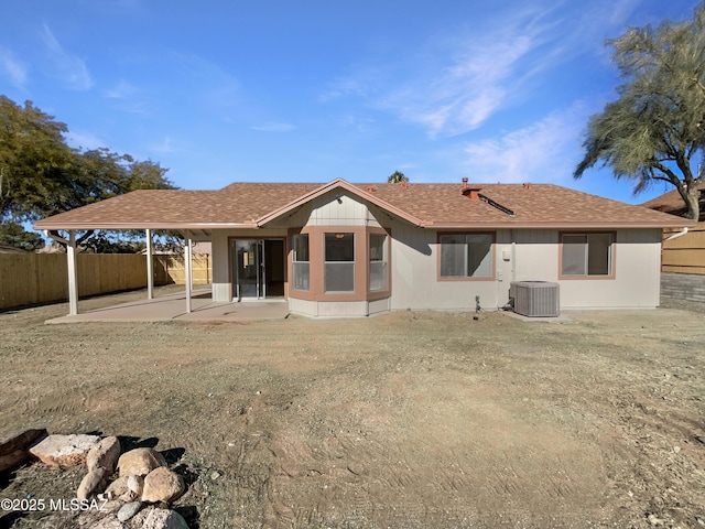 rear view of property featuring a patio, central AC, and a lawn