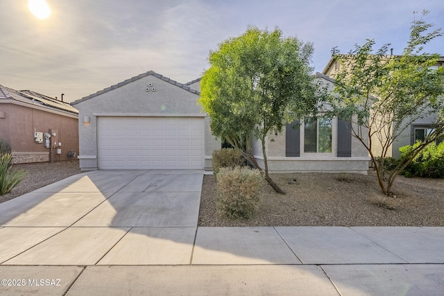view of front facade with concrete driveway, stucco siding, and an attached garage