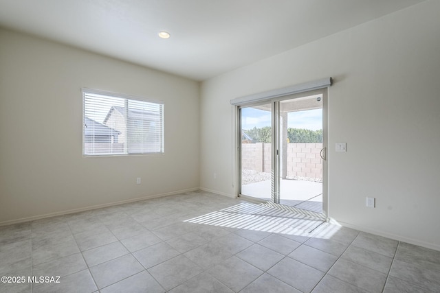 spare room with light tile patterned floors and baseboards