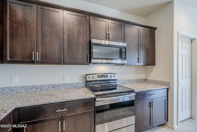 kitchen featuring dark brown cabinetry, light stone counters, and appliances with stainless steel finishes