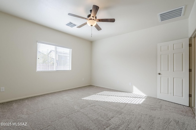 empty room featuring visible vents, a ceiling fan, and carpet floors