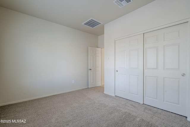 unfurnished bedroom with a closet and light colored carpet