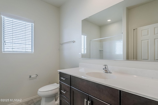 bathroom with vanity, baseboards, tile patterned floors, walk in shower, and toilet