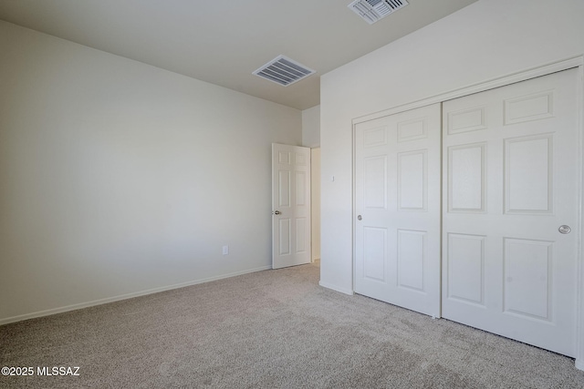 unfurnished bedroom with visible vents, baseboards, carpet flooring, and a closet